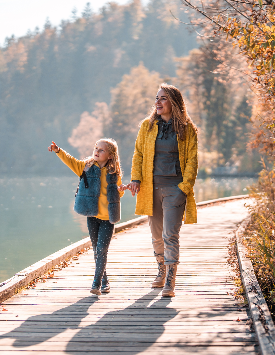 Frau mit Kind beim Spaziergang am See. 