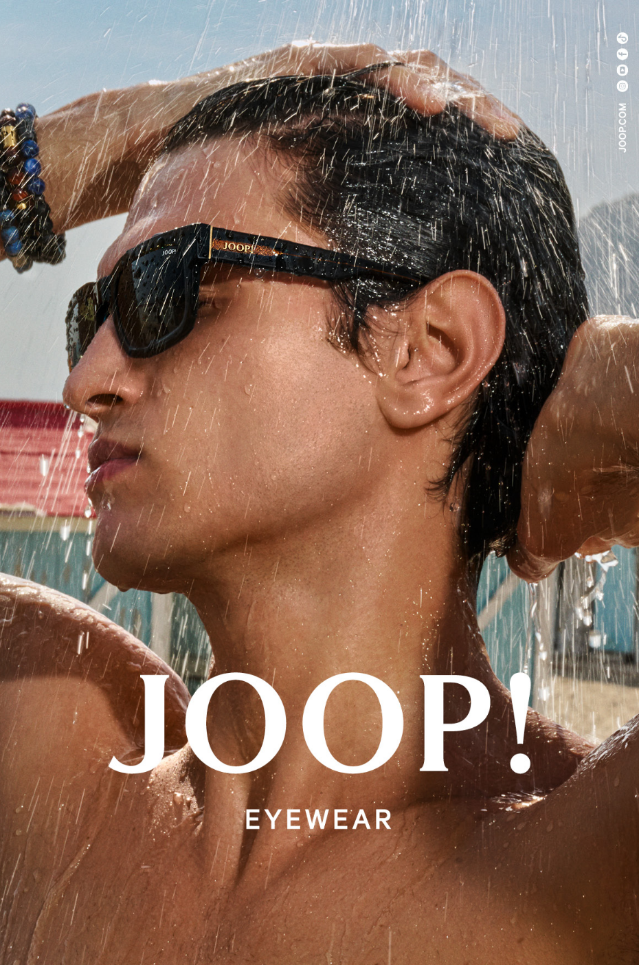 Joop: Mann mit Sonnenbrille duscht sich am Strand ab