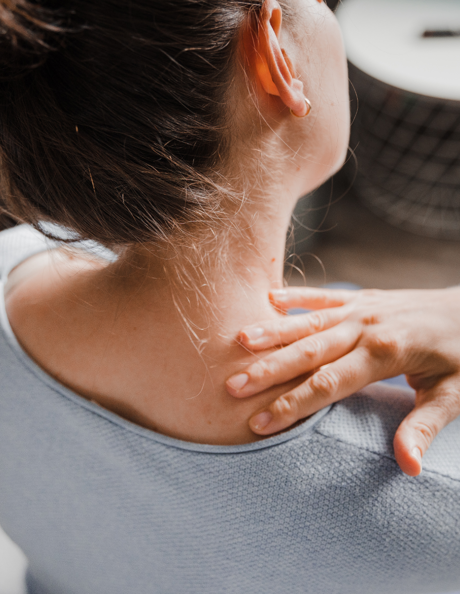 Frau greift sich in den Nacken.